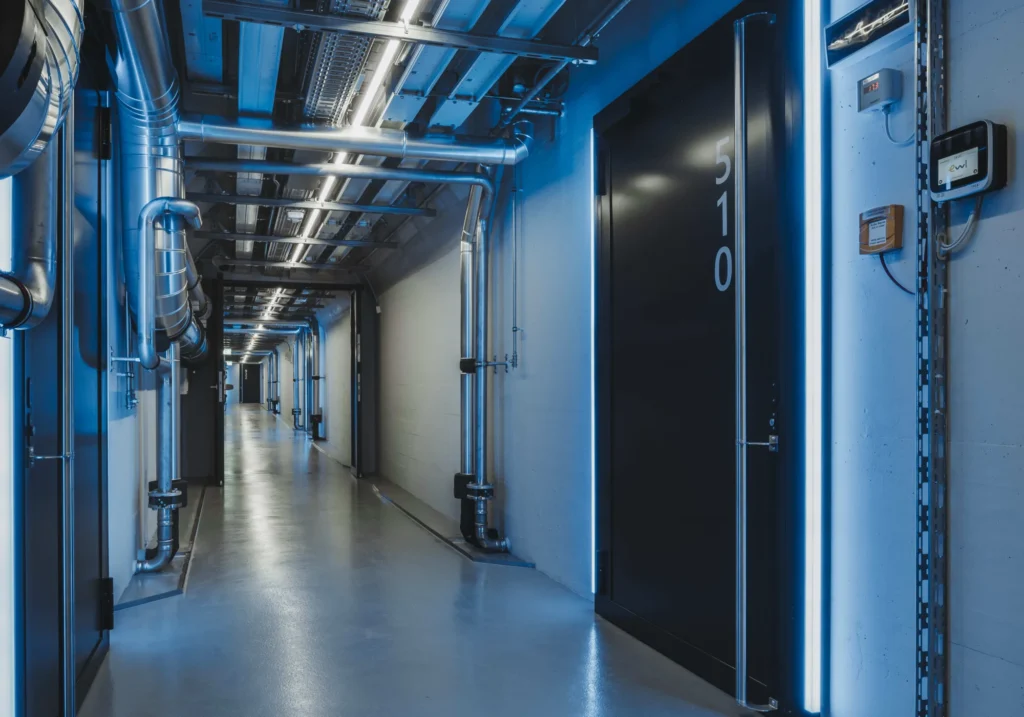 Gang im Rechenzentrum Stollen in Luzern mit technischer Infrastruktur und Leitungen.