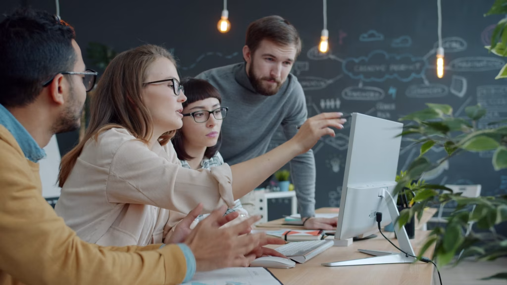 Digitale Zusammenarbeit: Team bespricht ein Projekt am gemeinsamen Bildschirm.